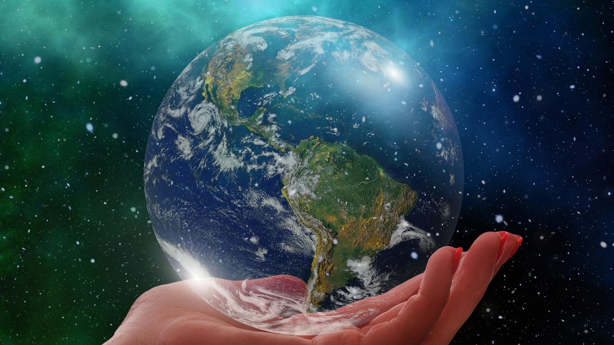 An image of a human hand holding the planet Earth in space.