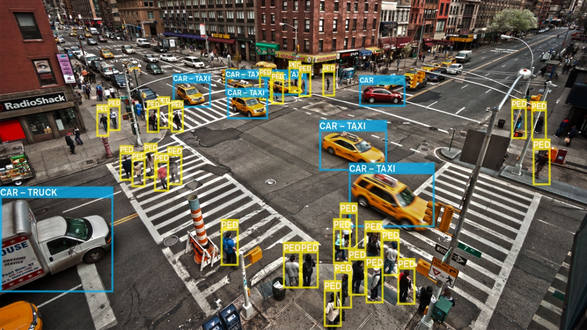 An overview of a busy intersection, with cars and pedestrians tagged by computer vision.