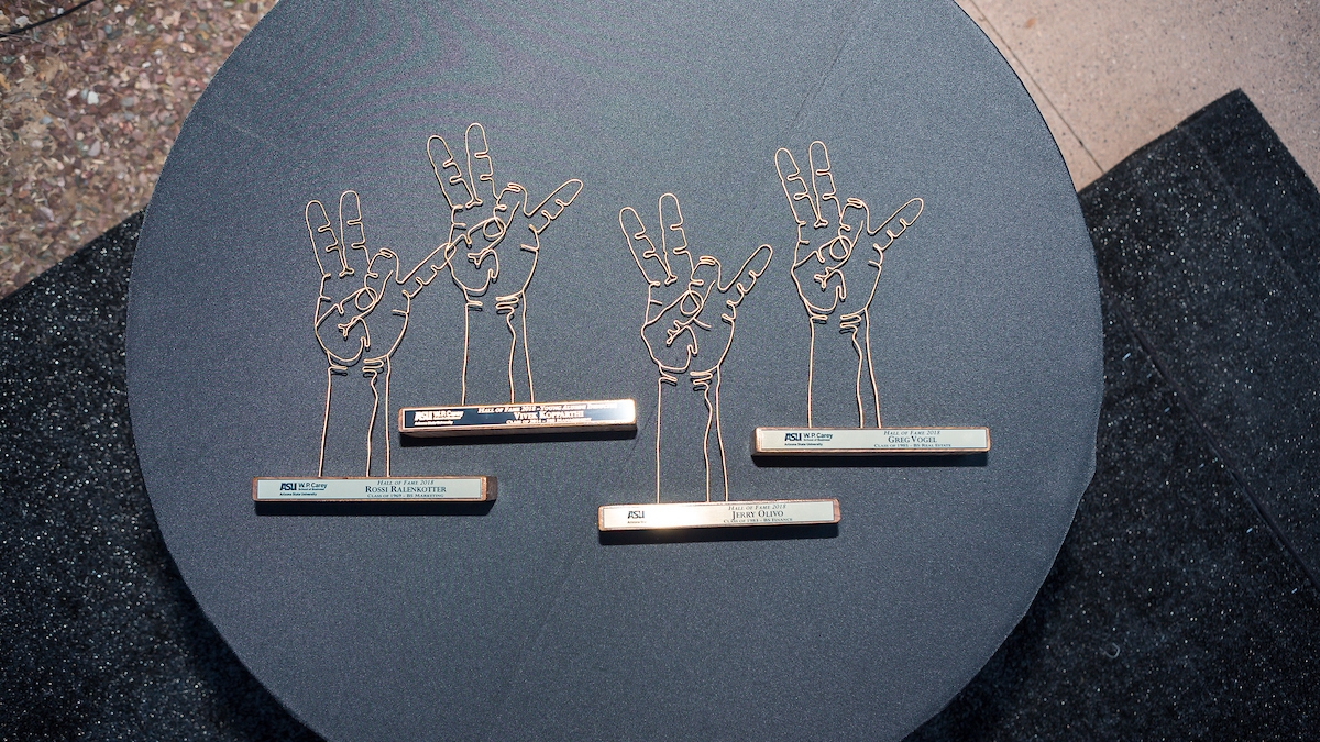 Awards fashioned out of gold wire in the shape of the ASU pitchfork against a black backdrop.
