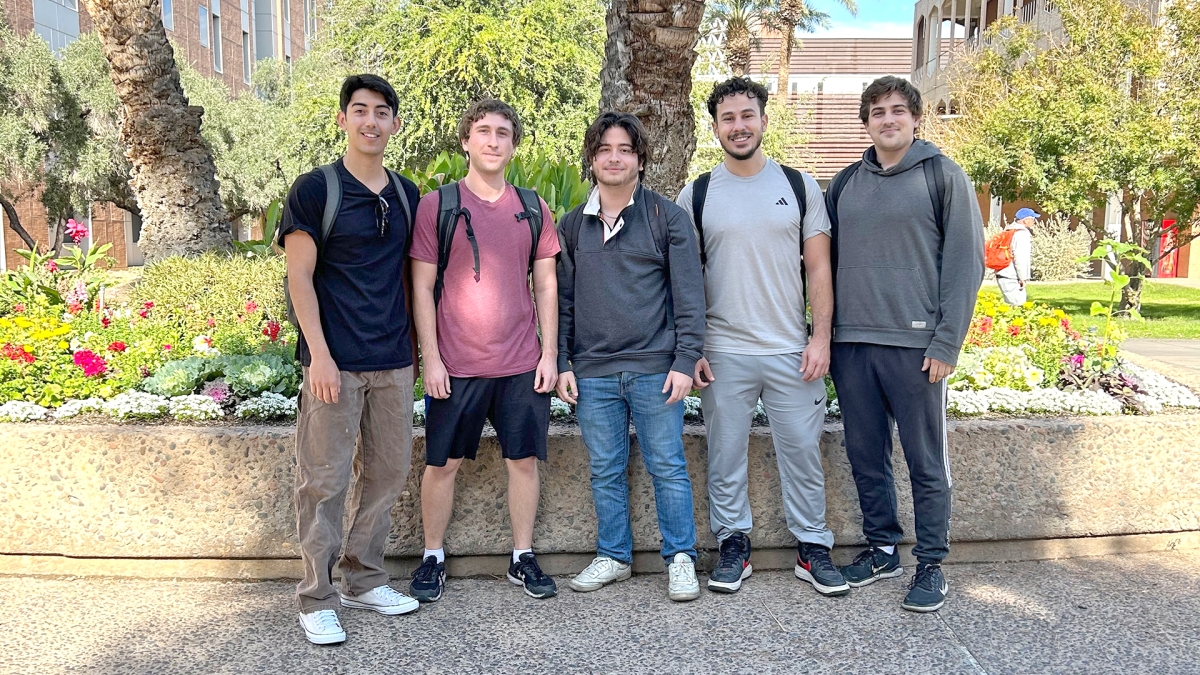 A group of five electrical engineering students standing in an outdoor setting.