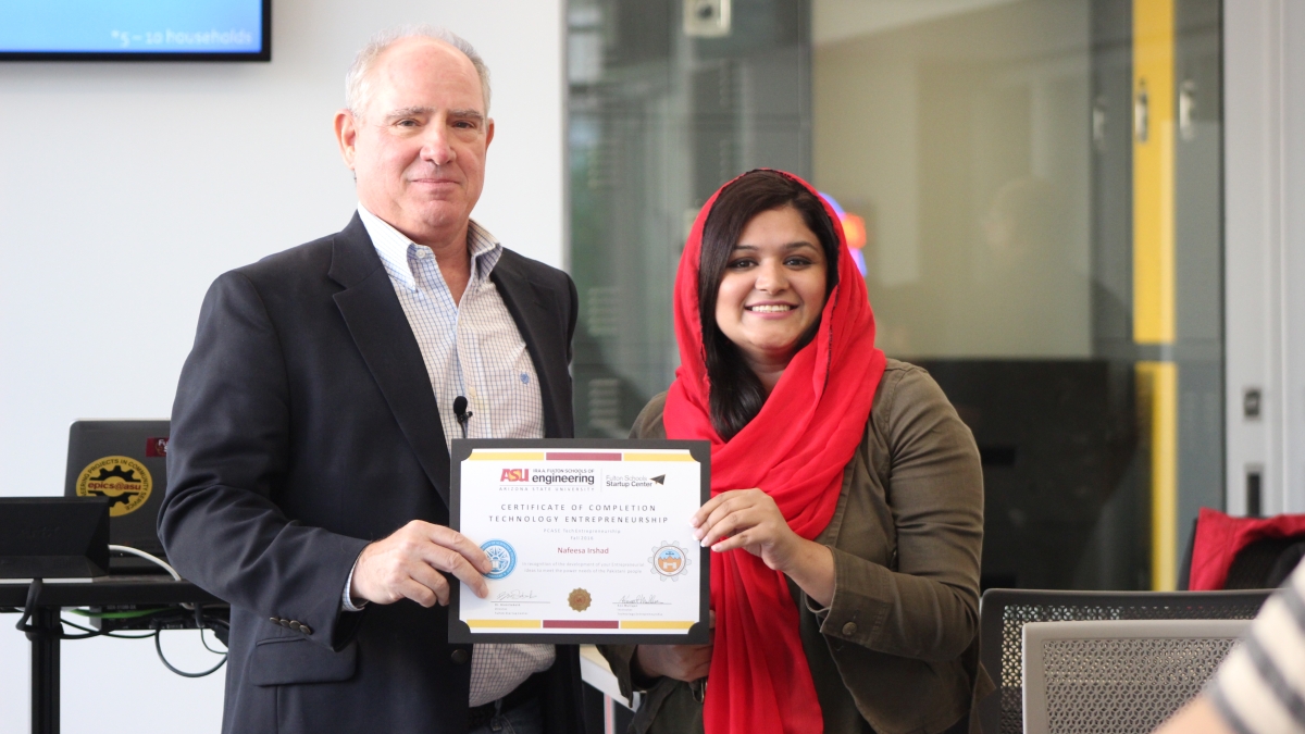 Kenneth Mulligan, professor for the U.S.-Pakistan Centers for Advanced Studies in Energy, presents Pakistani exchange scholar Nafeesa Irshad with her certificate of completion for the entrepreneurship portion of the program. Photographer: Erika Gronek/ASU