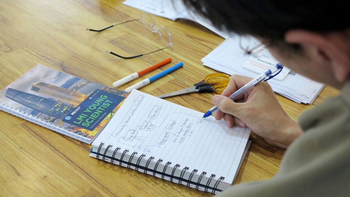 A Lower Mekong Initiative Young Scientist Program participant writes in a notebook. 