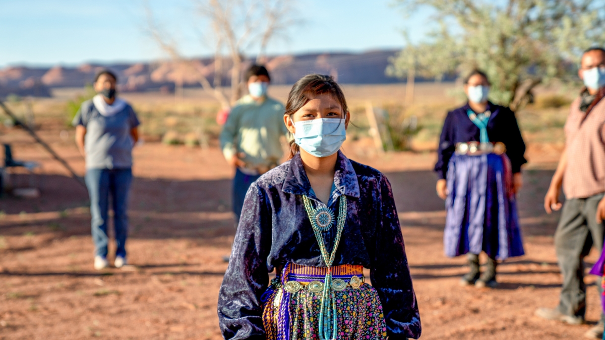 Navajo family wearing face coverings and practicing social distancing during the COVID-19 pandemic.