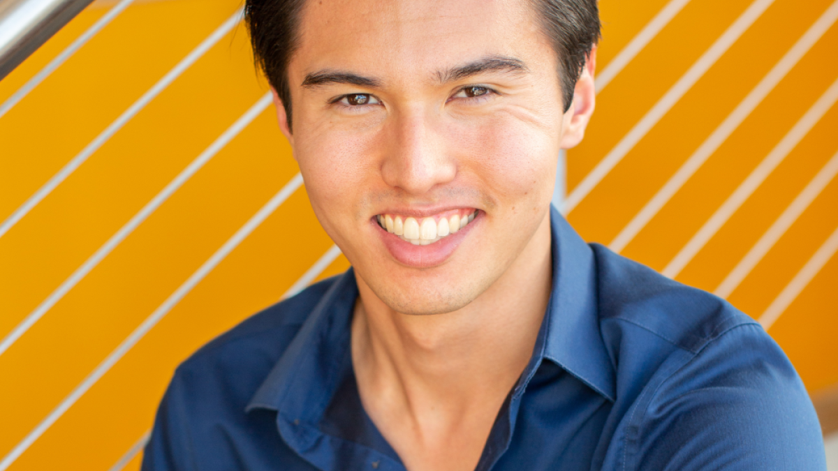 a headshot of JP Nelson sitting on a set of stairs