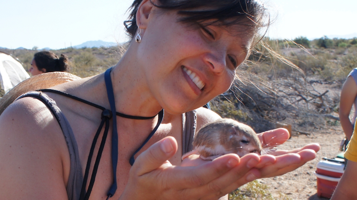 woman holding small mammal in her hands