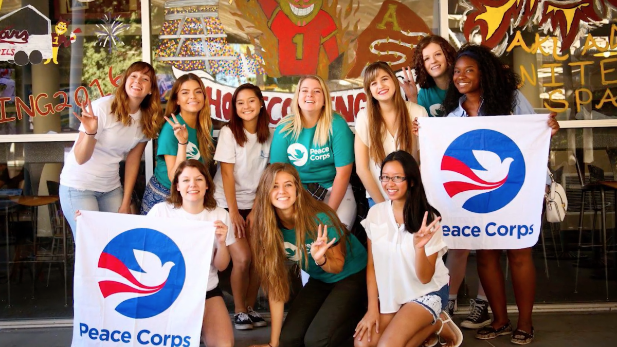 group photo of students holding peace corps signs