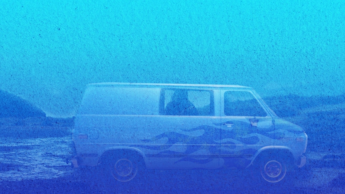 A blue van by a beach.