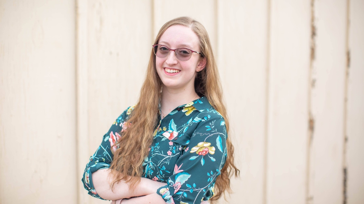 Madeleine Steppel photographed in a multi-colored button down shirt, wearing dark glasses.