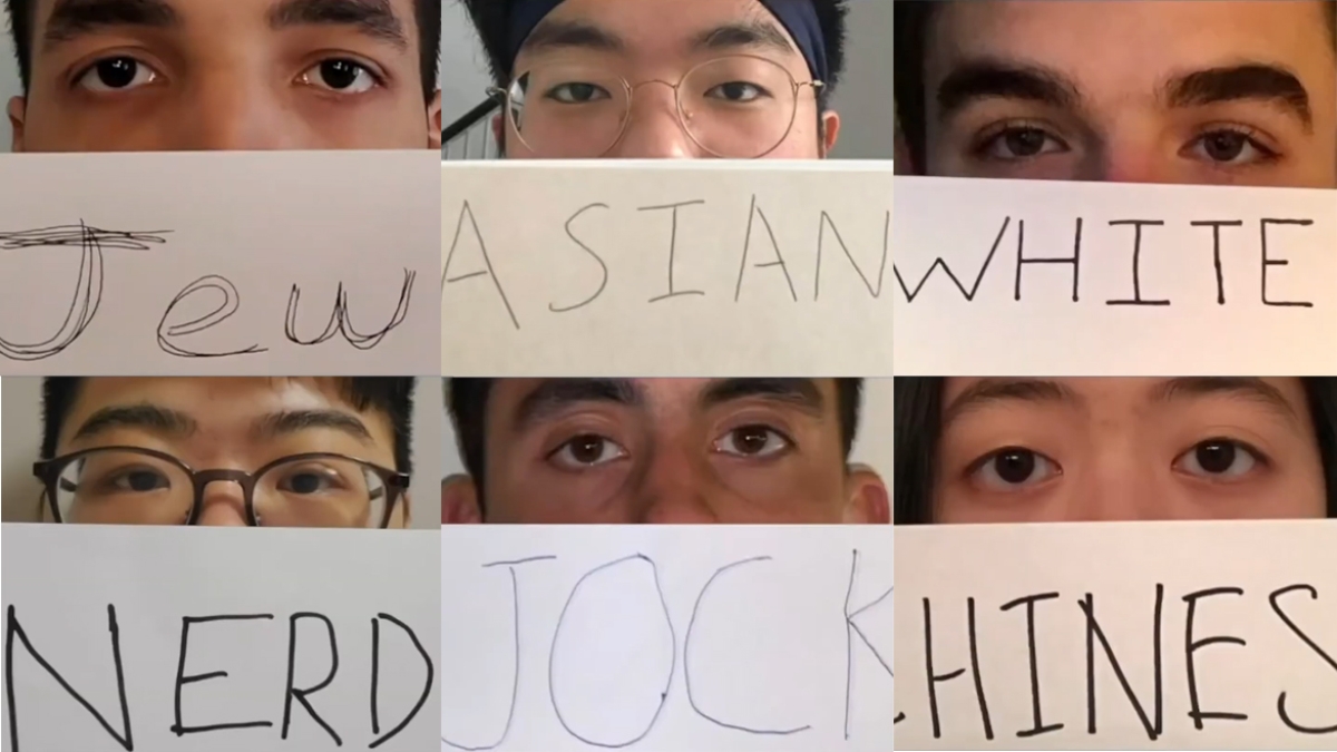 Students holding labels in front of their faces