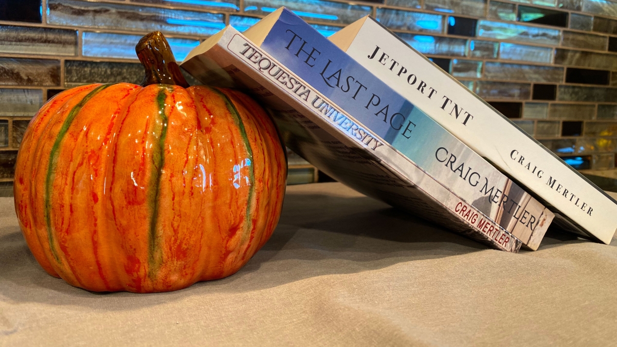books propped up against ceramic pumpkin