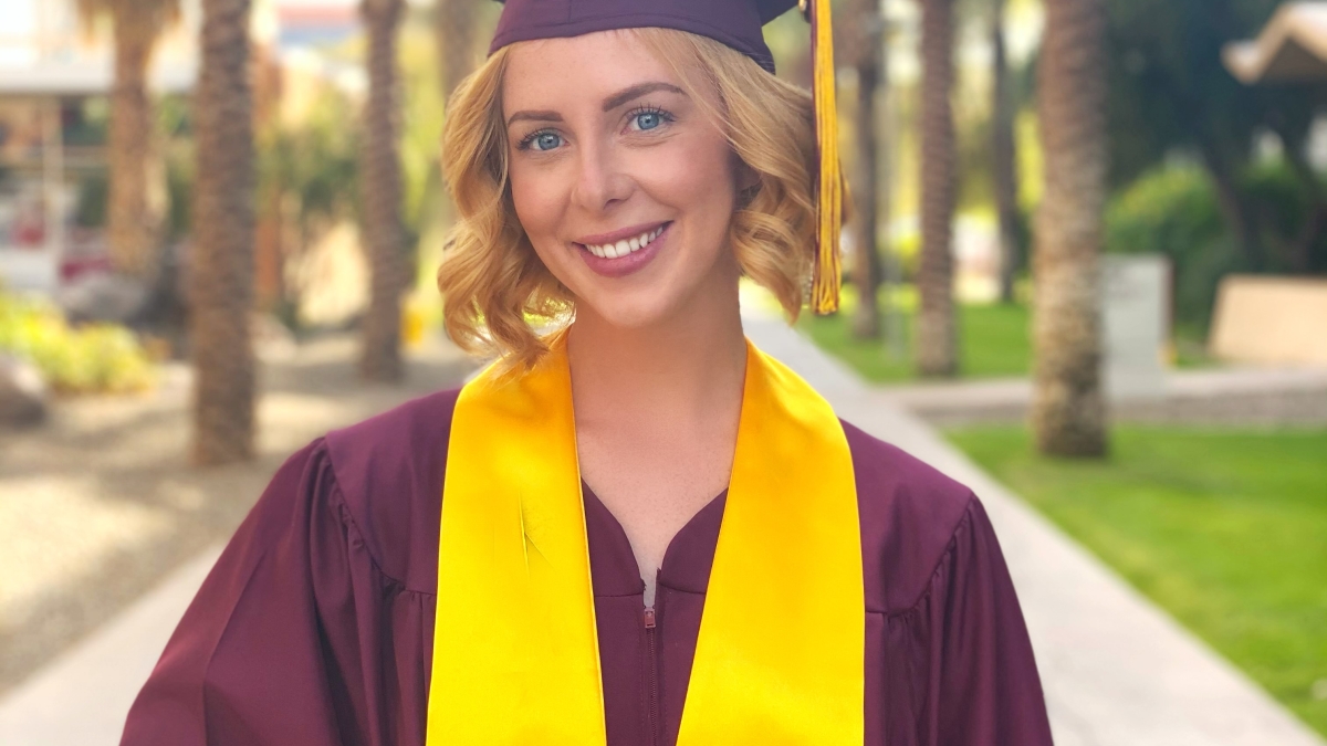 Molly Joy Lode stands in her cap and gown on ASU Tempe campus