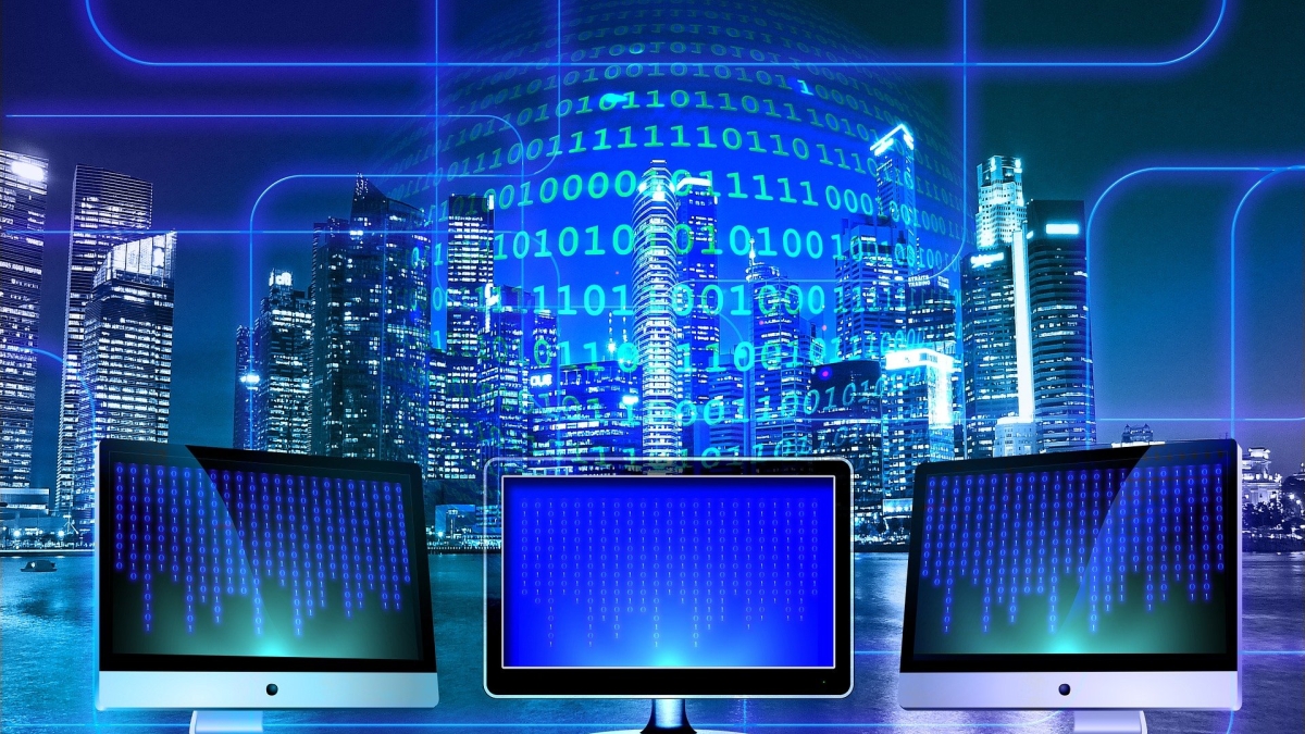 abstract image with computer screens in foreground and a city scape in the background