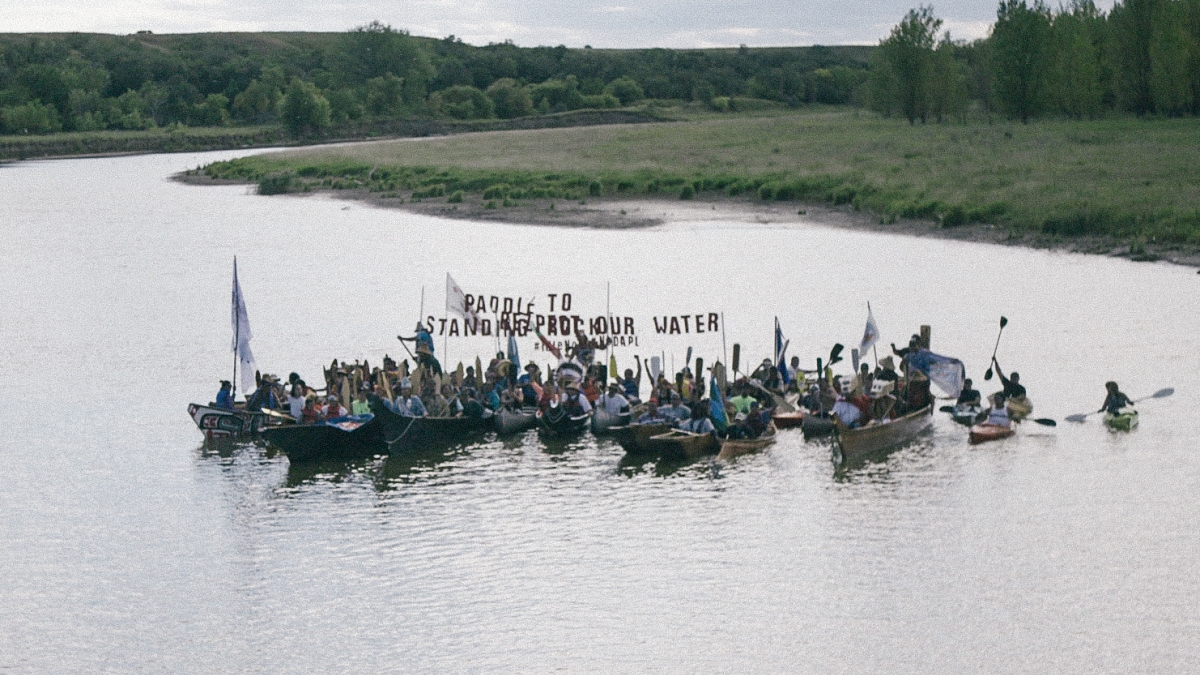 People gather in a river to protest in the movie Rise