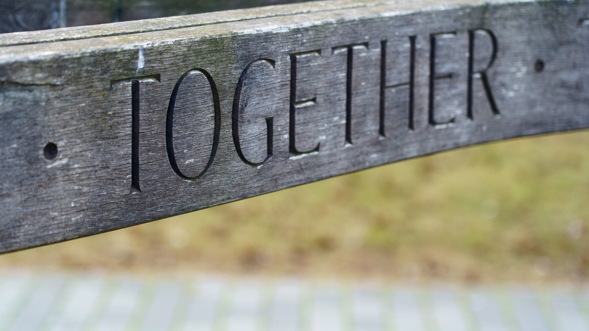 Close-up photo of a piece of wood that reads "Together."