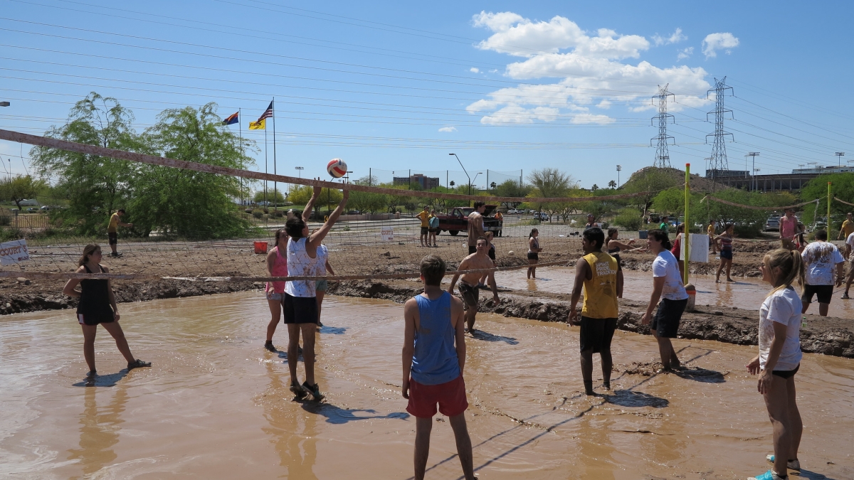 students playing mud volleyball