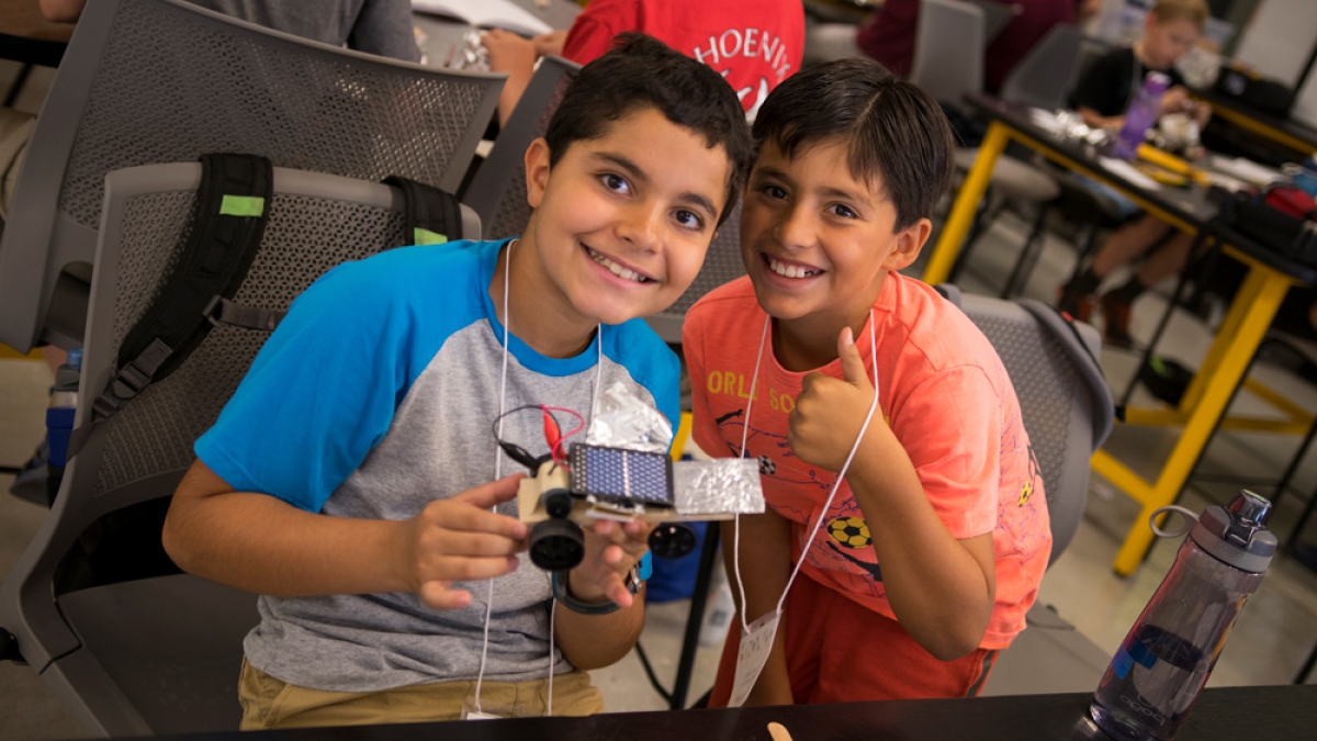 Two students hold up their creation from an engineering summer camp.
