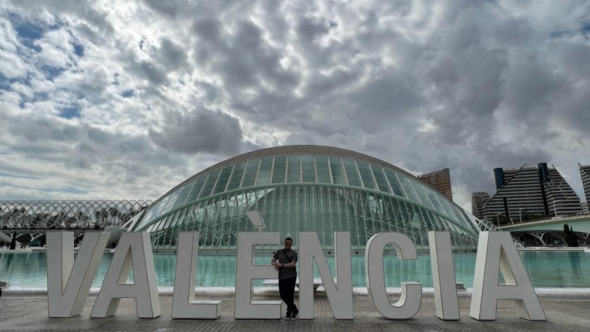 Large Valencia sign in Valencia, Spain, with landmark Hemisferic building in the background