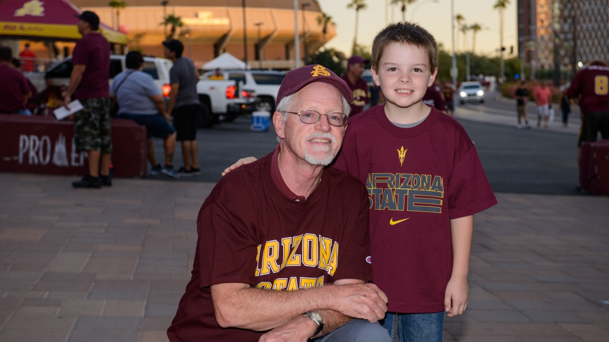ASU alumnus Michael Peddecord and his grandson Ryan attend an ASU football game.