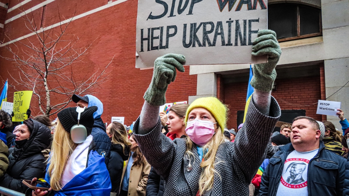 Woman holding sign that says "Stop War, Help Ukraine"