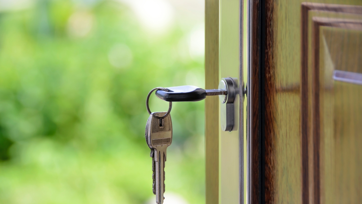 Close-up image of a key in a lock on a door of a home.