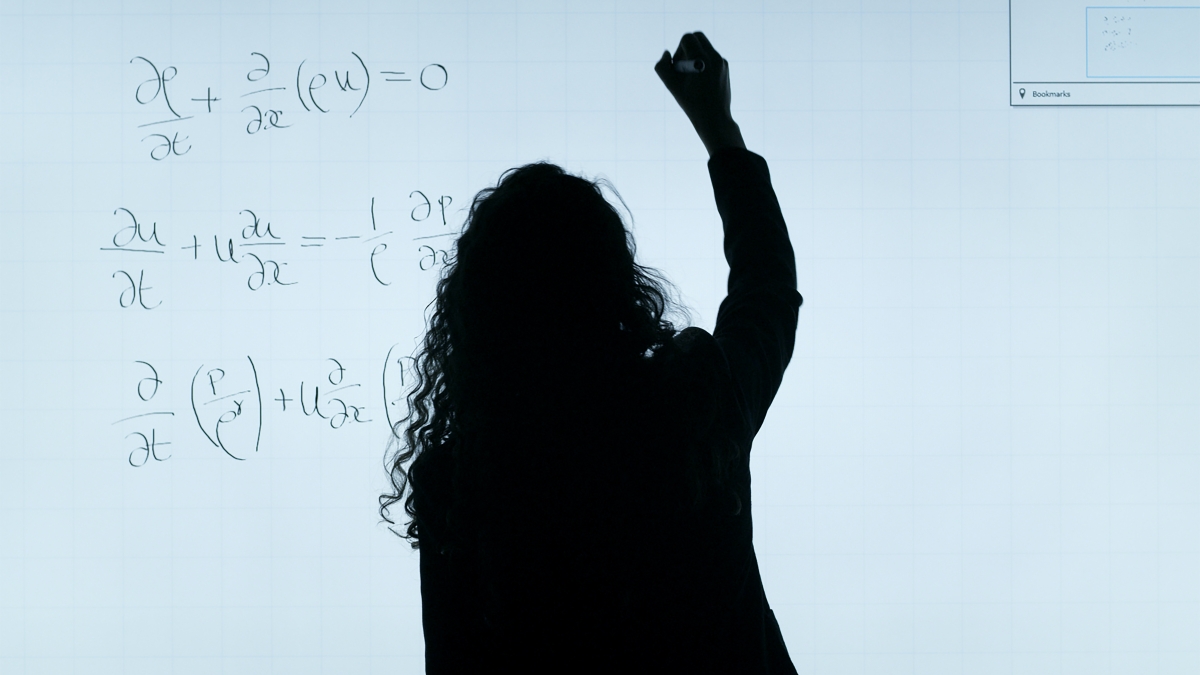 Woman writing equations on a whiteboard