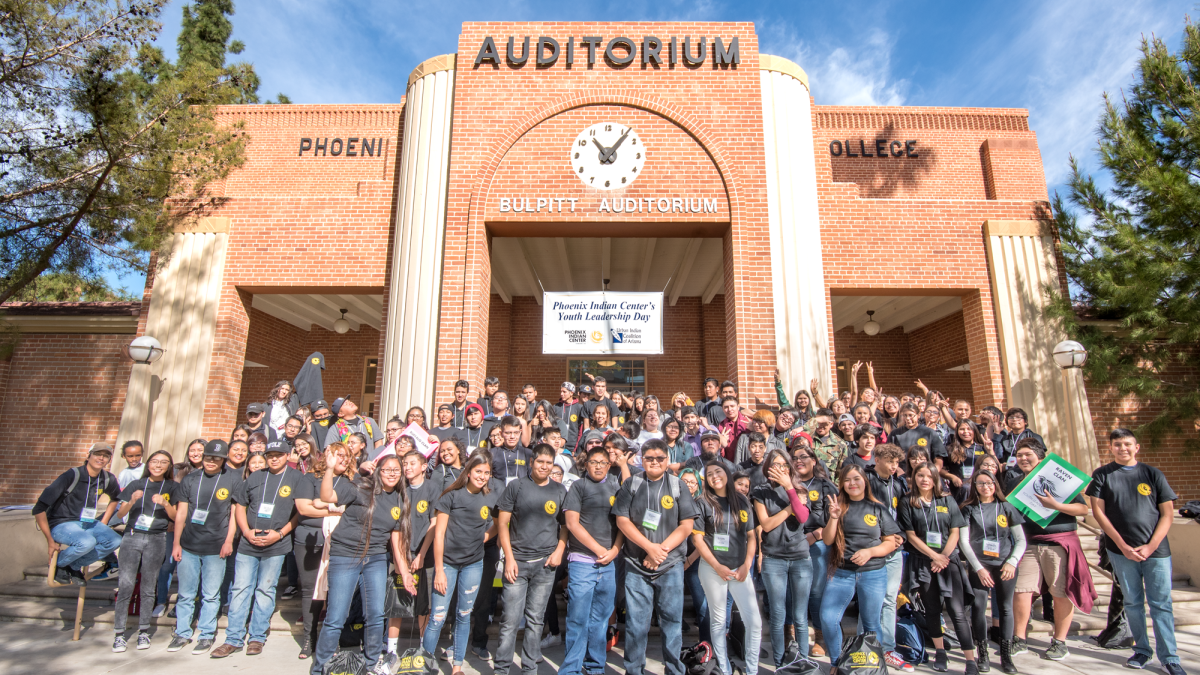 Participants in the Phoenix Indian Center Youth Leadership Day pose in front of an auditorium. / Photo by Phoenix Indian Center
