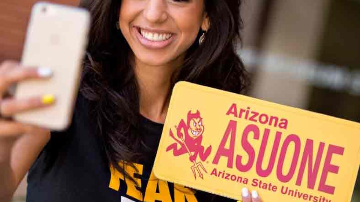 girl taking a selfie with ASU collegiate license plate