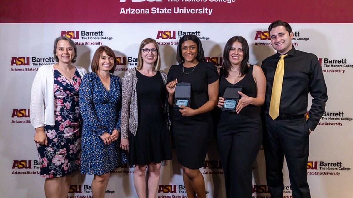 Photo of Barrett Poly Gold Standard Award winners holding awards and standing in a line together smiling at the camera in front of an ASU Barrett backdrop.
