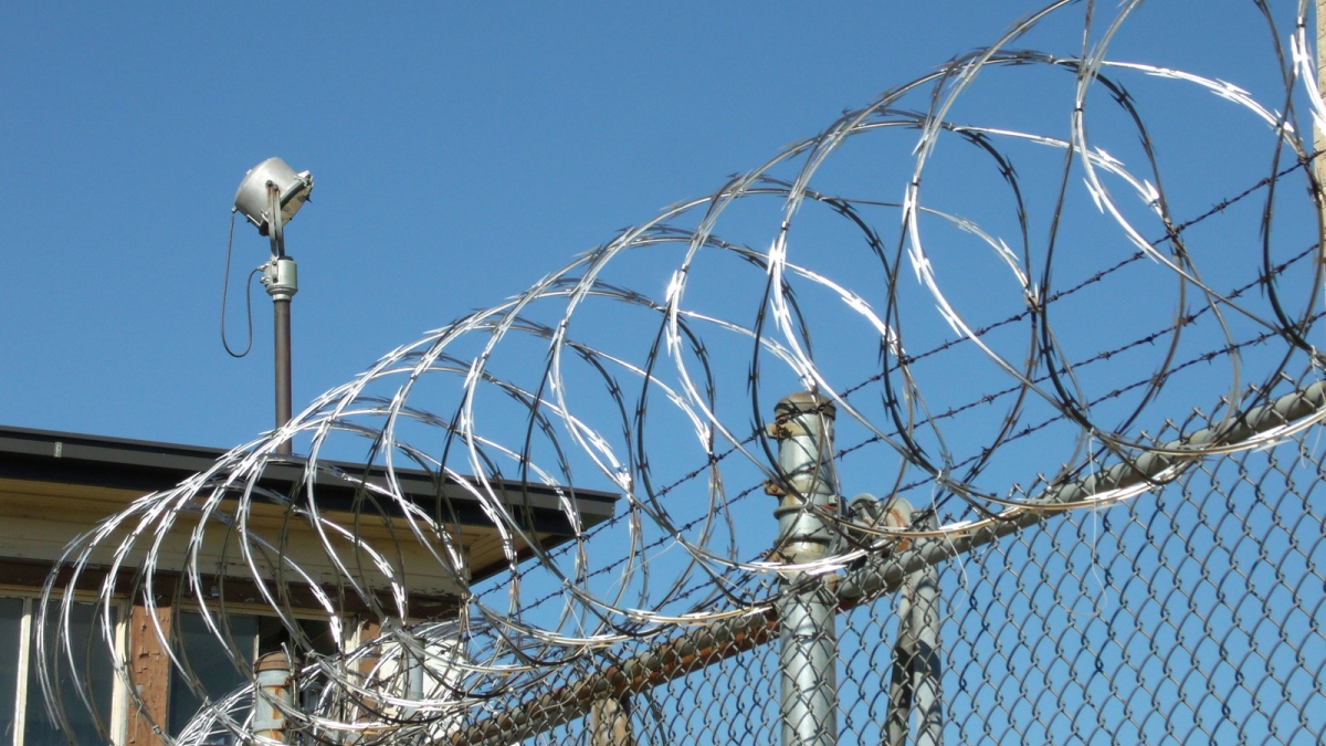 A prison fence with a security camera