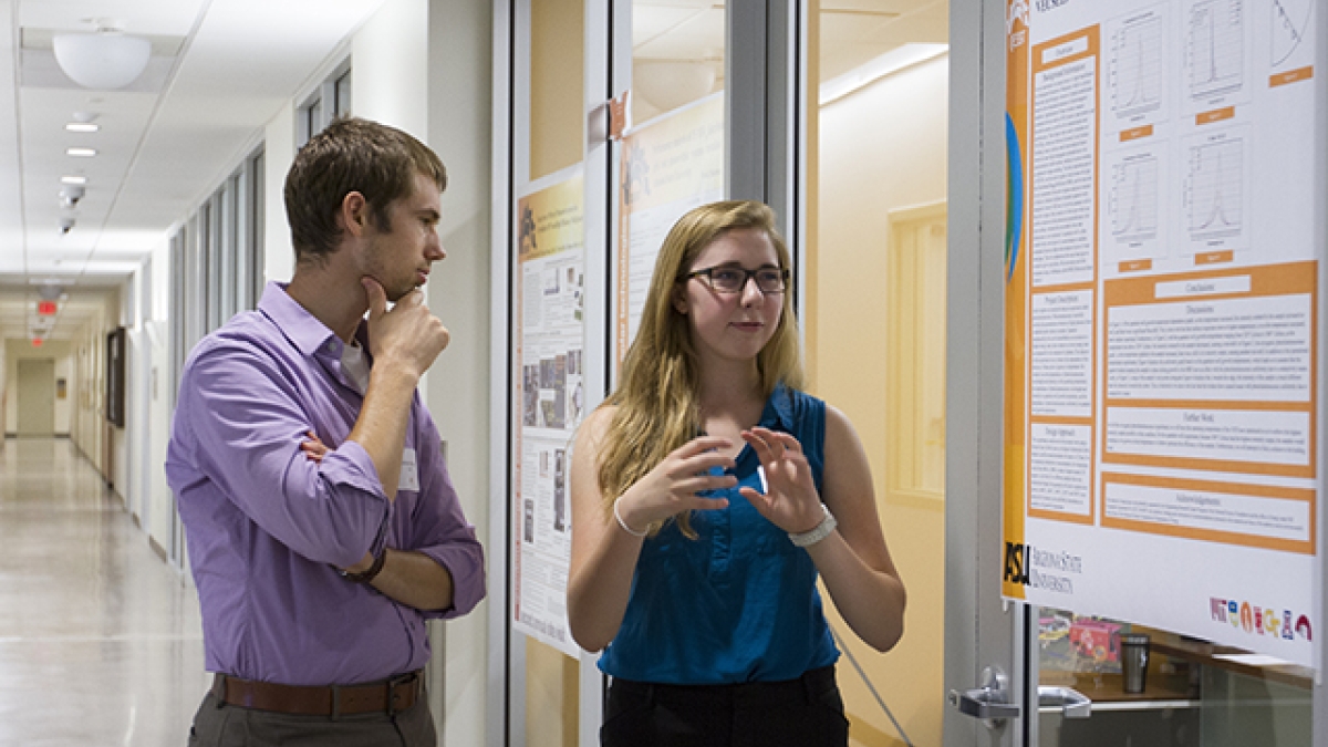Cailin Treseder, a University of New Mexico student with a Research Experiences for Undergraduates pilot program, presents her research to assistant professor Zachary Holman in the summer of 2013.