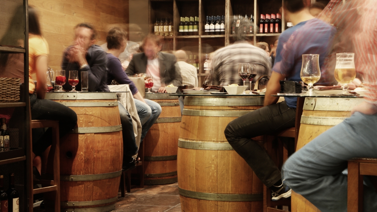 restaurant where people are sitting around at tables shaped like barrels