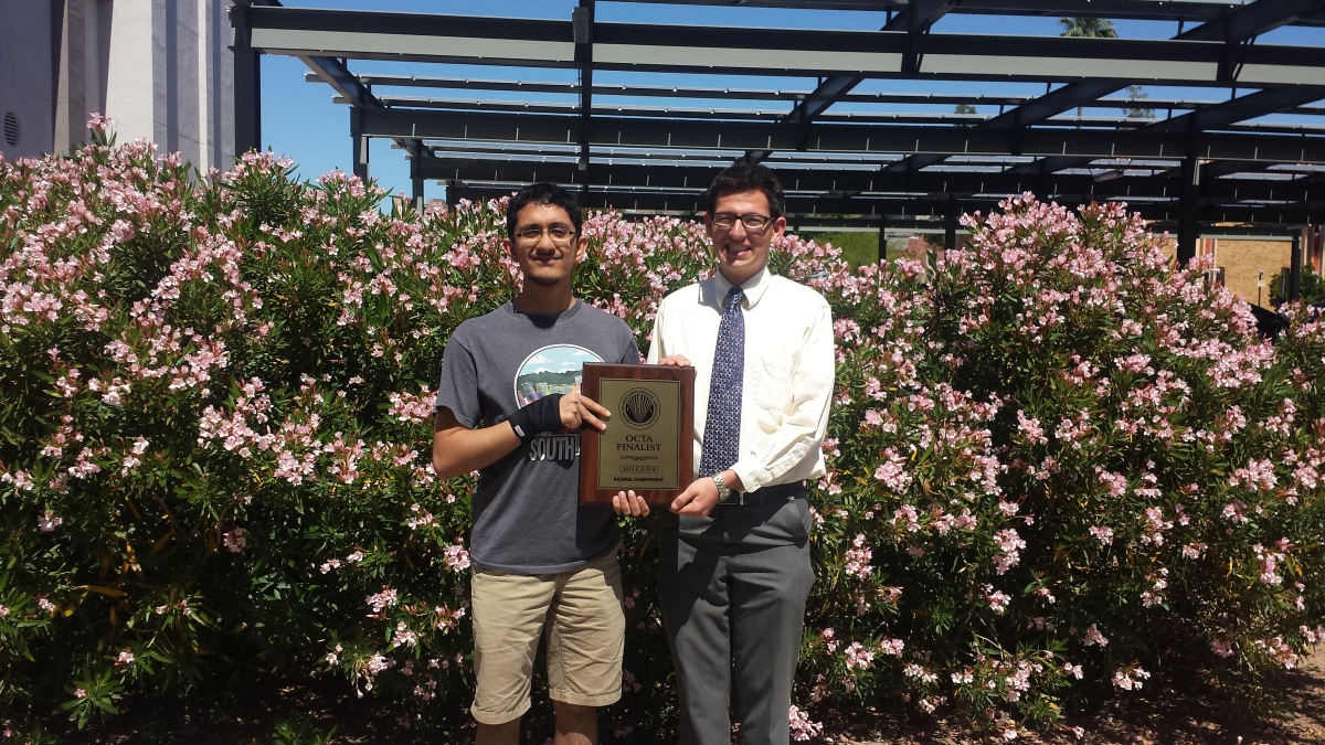 two students holding a plaque