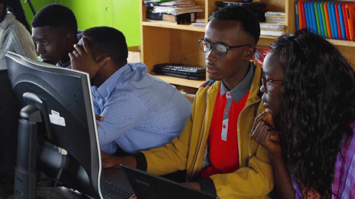 Students in Rwanda use a computer in a classroom