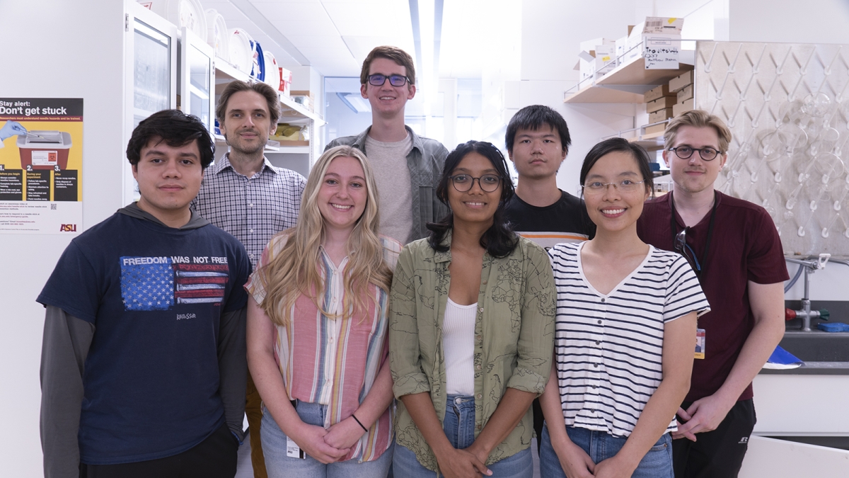ASU Associate Professor Ryan Tovitch and a group of students post for a photo in a lab.