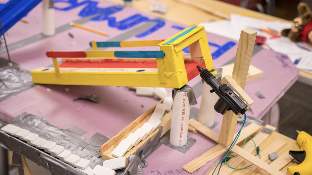 A chain reaction machine made from household objects such as clothes pins and popsicle sticks.