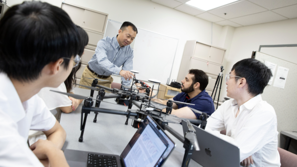 Group of researchers talking in a lab setting.