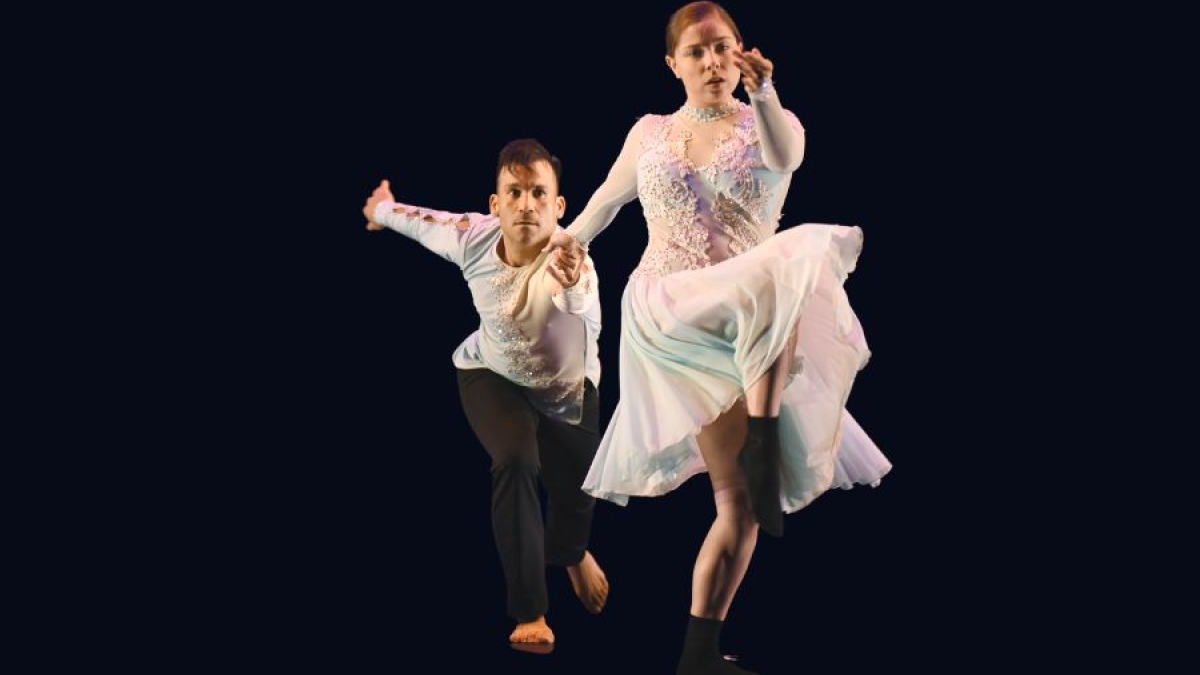 Two dancers perform a latin dance in costume.