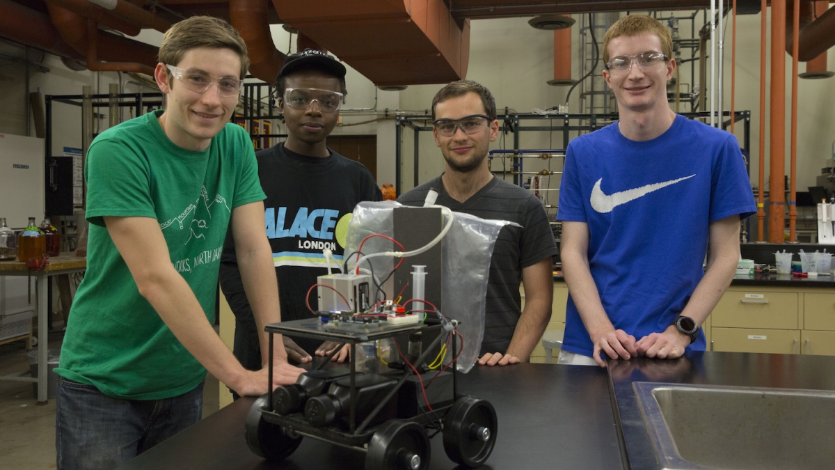 Photo of Jayse Langdon, Jon Simiyu, Andrew Dopilka and Alex Cook as they work on their fuel-cell-powered car in preparation for the national American Institute of Chemical Engineers' Chem-E-Car competition this November. 