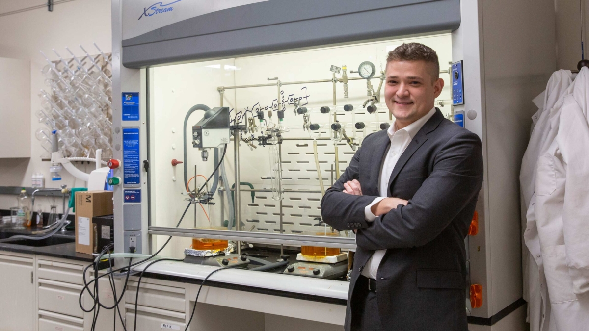 ASU Associate Professor Mathew Green standing with arms crossed and smiling in a laboratory setting.