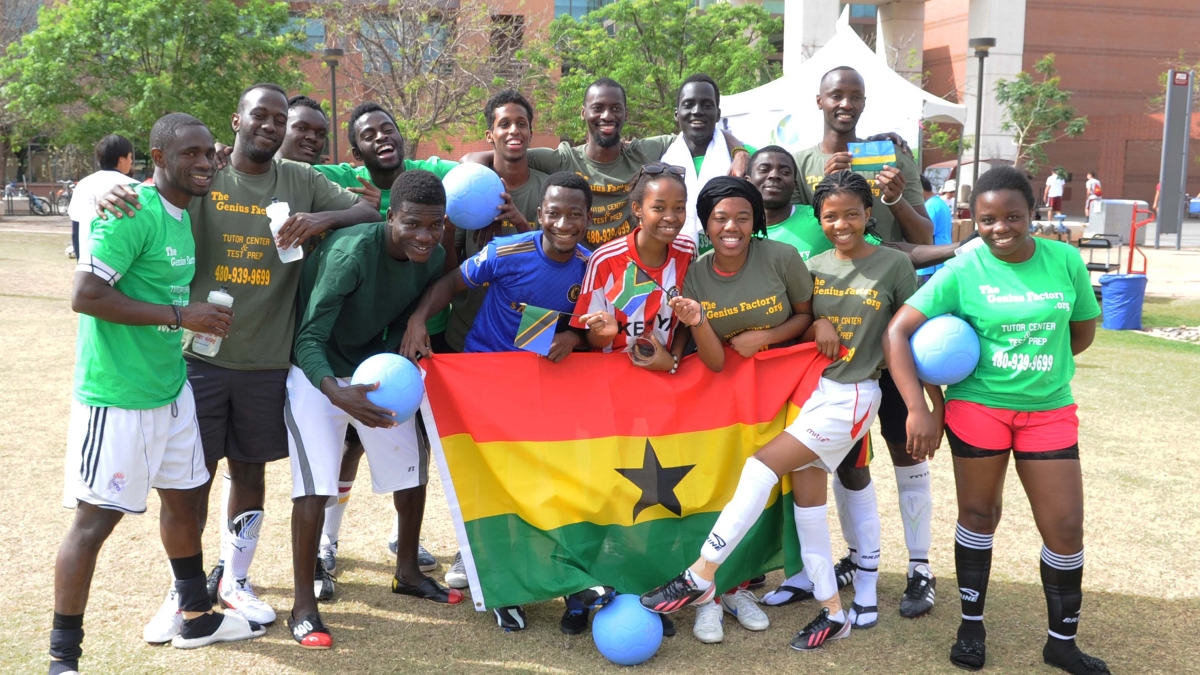 MasterCard Foundation Scholars pose with flags and soccer balls at charity event