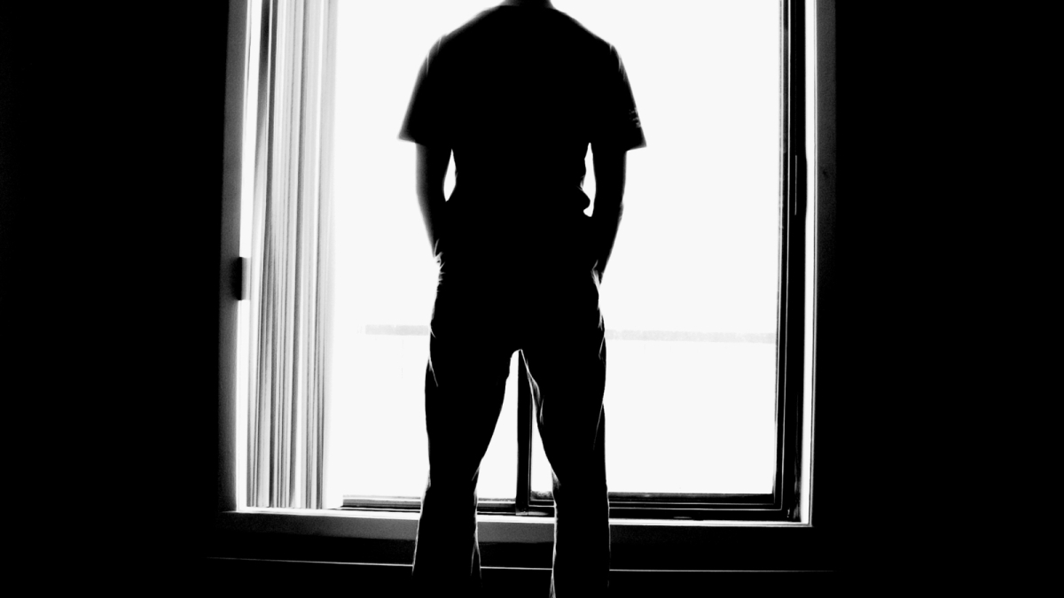 Man stands at a window.