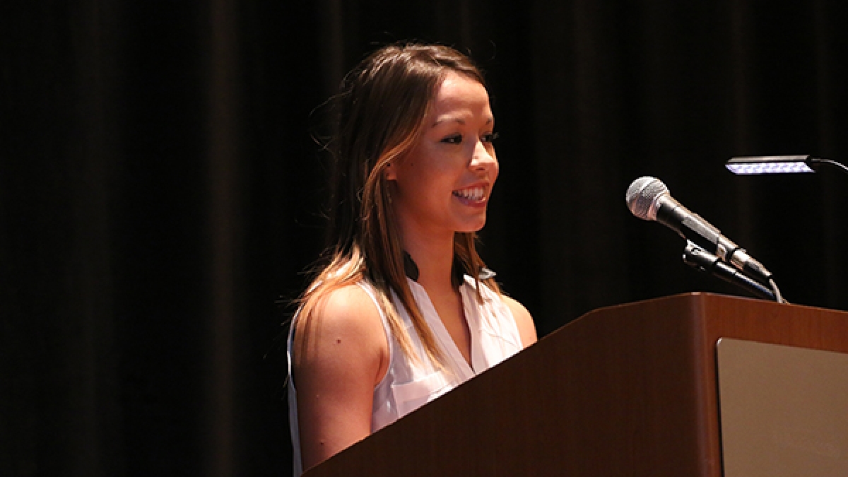 student speaking at podium during luncheon