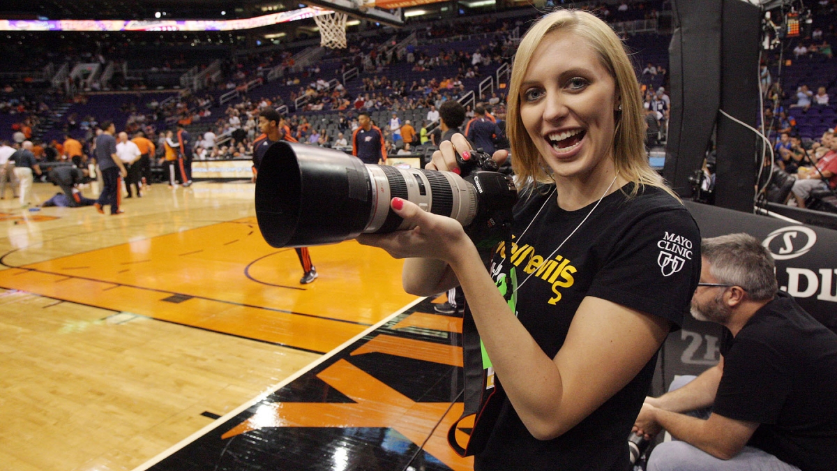 student holding a camera at a sporting event