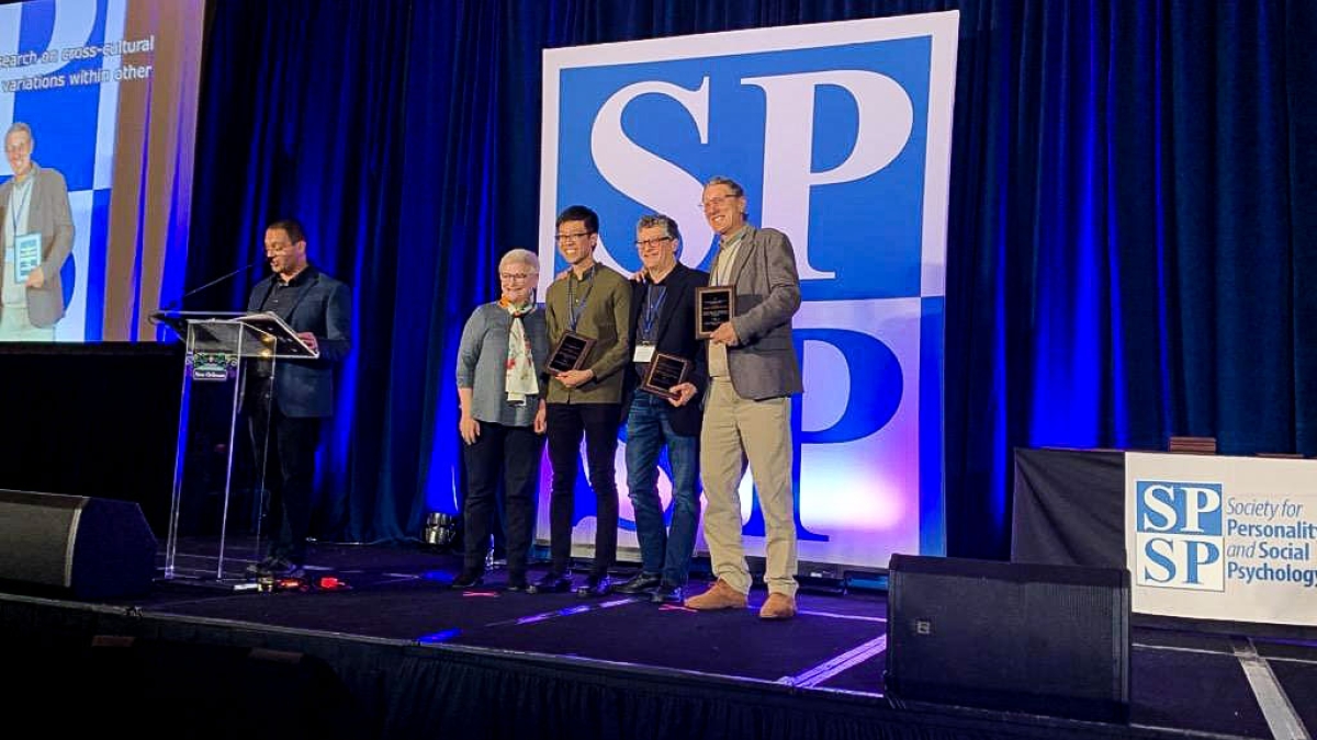 four professors on a stage accepting an award