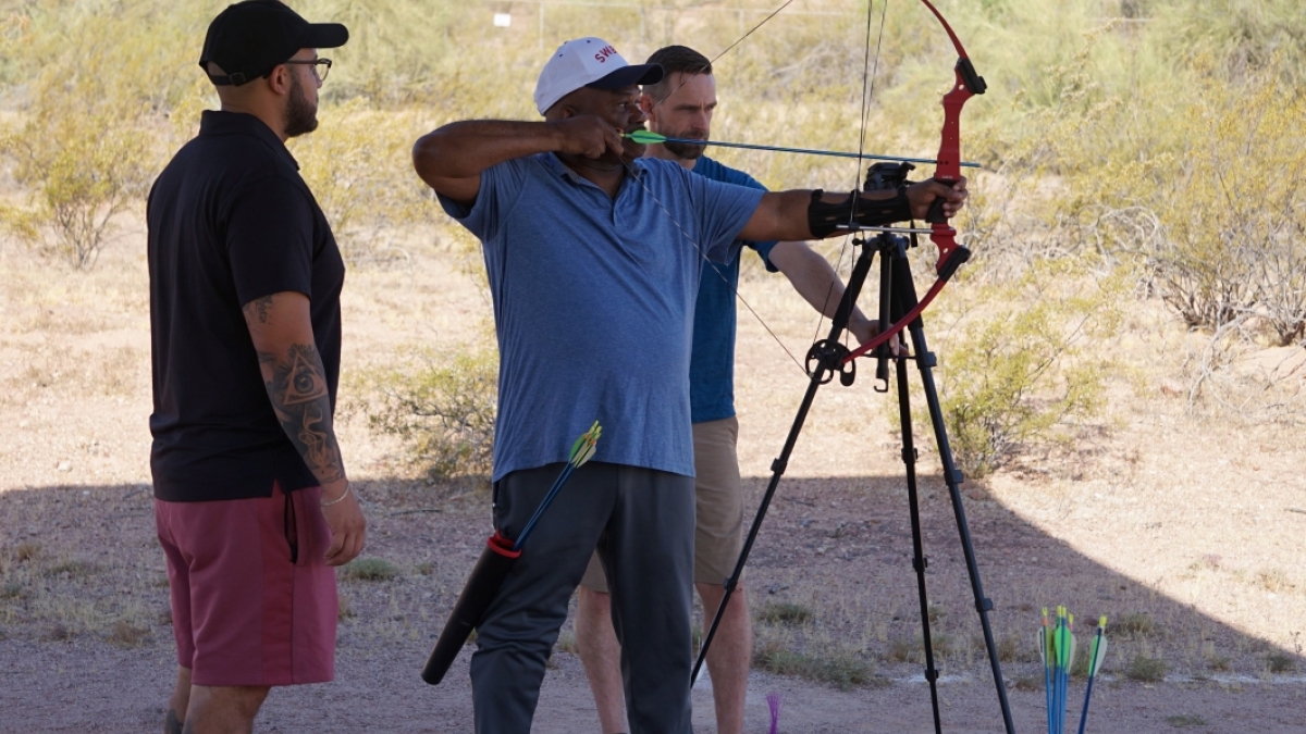 James Malone shoots an arrow as Rick Alvarado and Josh Parks watch