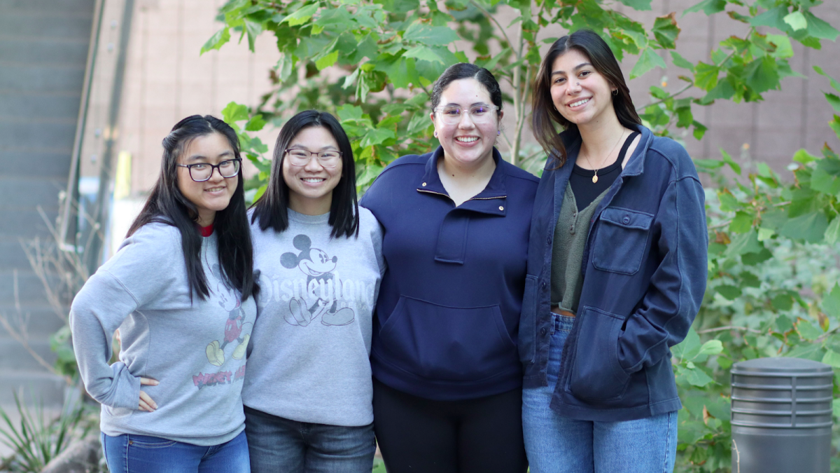 The undergraduate coaches, Alaina Wong, Anna Hinojosa, Anne Nguyen and Tiffany Rascon, pictured standing together and smiling in an outdoor setting.