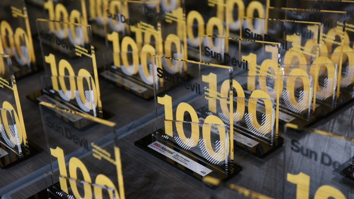 table full of glass awards featuring the number 100