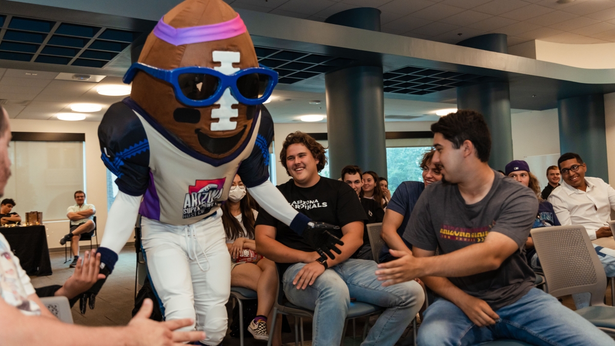 Super Bowl mascot Spike, a giant football, greets ASU students at a panel event.