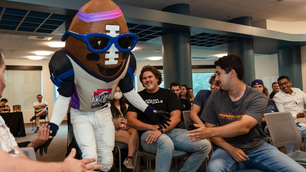 Super Bowl mascot Spike, a giant football, greets ASU students at a panel event.