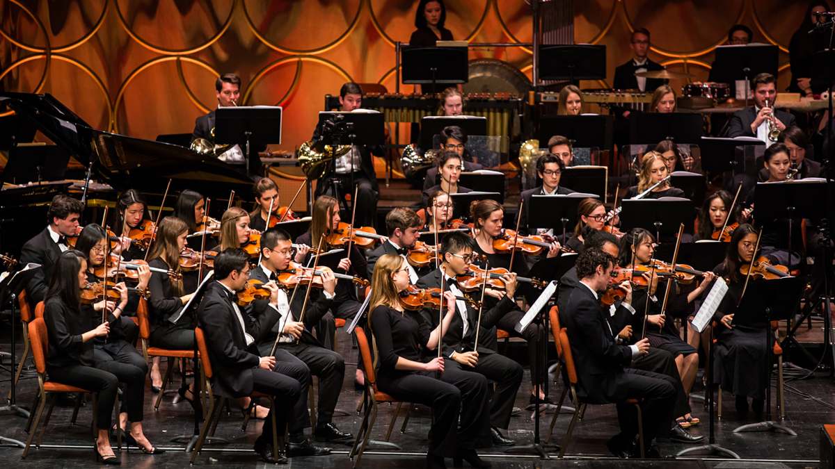 An orchestra performing on stage.